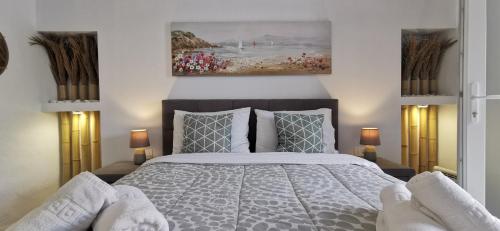 a bedroom with a bed and a painting on the wall at Alexandra's Home in Fira