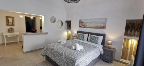 ein Schlafzimmer mit einem Bett mit zwei weißen Handtüchern darauf in der Unterkunft Alexandra's Home in Fira