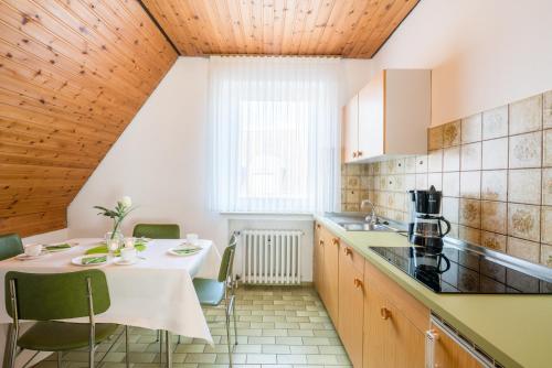 a kitchen with a white table and chairs at Hotel Kemper in Havixbeck