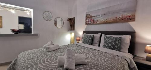 a bedroom with a large bed with towels on it at Alexandra's Home in Fira