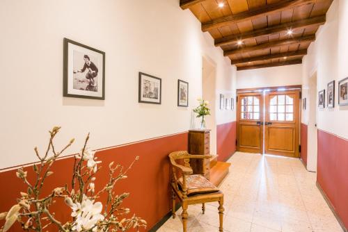 a hallway with orange and white walls and a chair at Hotel Kemper in Havixbeck
