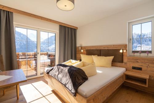 a bedroom with a bed and a large window at Hotel Bergmahd in Steeg