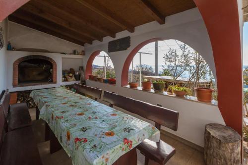 a dining room with a table and two arched windows at BRISKI in Crikvenica