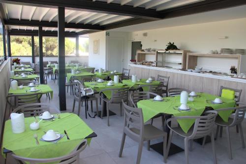 a dining room with green tables and chairs at Hotel La Pigna in Lignano Sabbiadoro