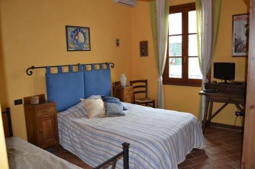 a bedroom with a bed and a desk and a window at B&B Pane e Rose in San Miniato