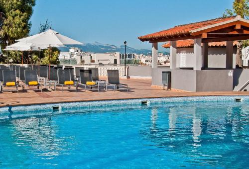 a swimming pool with chairs and an umbrella on a building at BQ Augusta Hotel in Palma de Mallorca