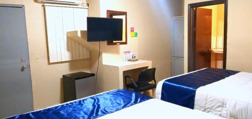 ein Hotelzimmer mit 2 Betten und einem Flachbild-TV in der Unterkunft Pearl Point Hotel in Puerto Peñasco