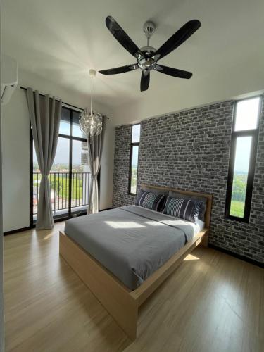 a bedroom with a ceiling fan and a brick wall at Sky Cafe Penthouse Suite by myProStay in Alor Setar