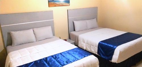 2 Betten in einem Hotelzimmer mit in der Unterkunft Pearl Point Hotel in Puerto Peñasco