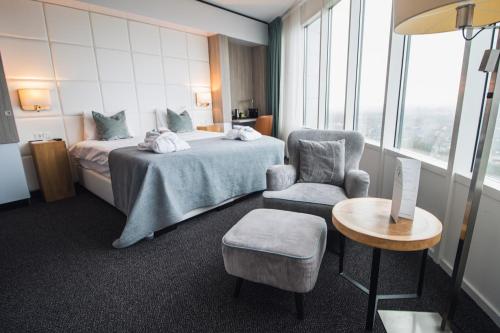 a hotel room with a bed and a chair and a table at Van der Valk Hotel Tiel in Tiel