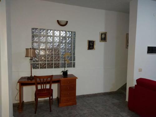 einen Schreibtisch und einen Stuhl in einem Zimmer mit Fenster in der Unterkunft Casa Mari Carmen in Adeje