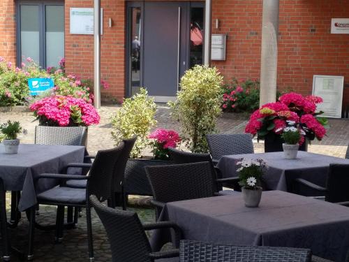 a group of tables and chairs with flowers on them at Hotel Kemper in Havixbeck