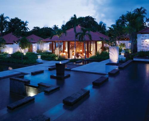 a villa with a swimming pool at night at Grand Hyatt Bali in Nusa Dua