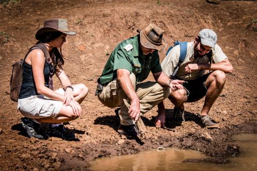 a group of three people sitting in the mud at African Hills Safari Lodge & Spa in Magaliesburg
