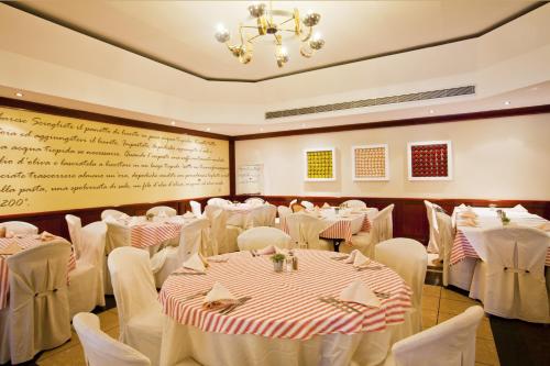 a banquet hall with white tables and chairs at Kipriotis Village Resort in Kos Town