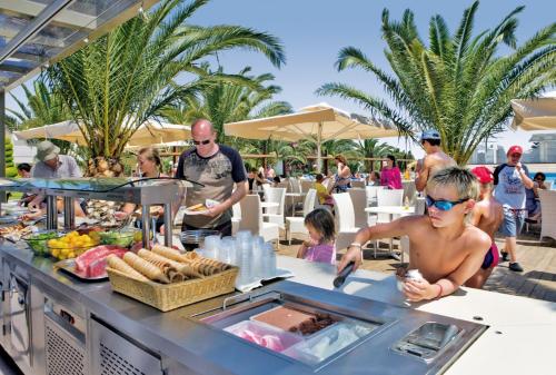 a man preparing food at a buffet at a resort at Kipriotis Village Resort in Kos Town