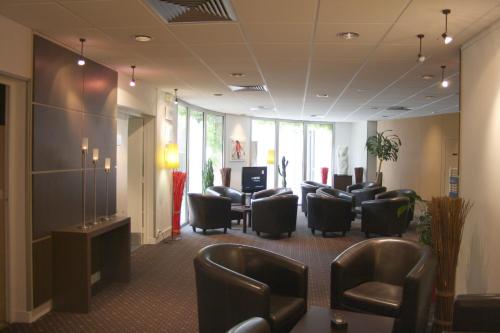 a waiting room with leather chairs and a waiting room at La Berteliere, The Originals Relais in Saint-Martin-du-Vivier