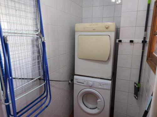 ein kleines Bad mit einer Waschmaschine und einem WC in der Unterkunft Casa Mari Carmen in Adeje