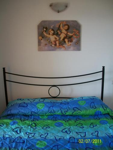 a bedroom with a bed with a painting on the wall at Miramare Isola Rossa in Isola Rossa
