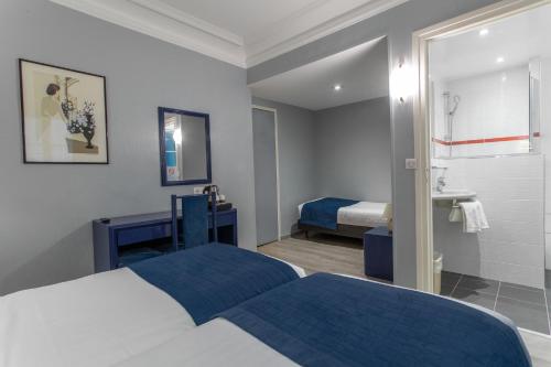 a hotel room with two beds and a sink at Résidence du Pré in Paris