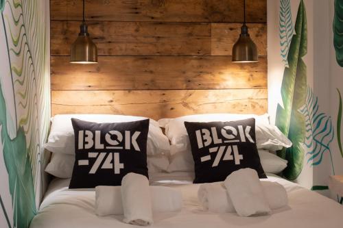 a bed with two pillows and a wooden headboard at Blok-74 in Brighton & Hove