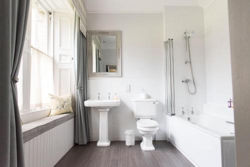 a bathroom with a sink and a toilet and a bath tub at Balbirnie House Hotel in Glenrothes