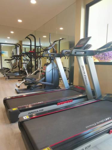 a gym with several cardio machines in a room at S Bangkok Hotel, Navamin in Ban Khi Sua