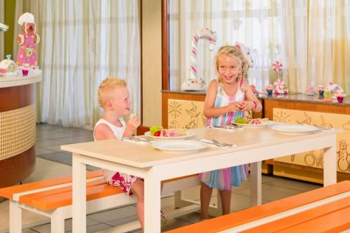 two children sitting at a table in a barbie room at Kipriotis Village Resort in Kos Town