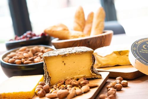 a table topped with cheese and bread and other foods at Radisson Blu Hotel, Rouen Centre in Rouen