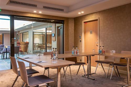 a conference room with wooden tables and chairs at Radisson Blu Hotel, Rouen Centre in Rouen