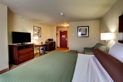 a hotel room with a bed and a flat screen tv at Stanton Inn and Suites in Stanton