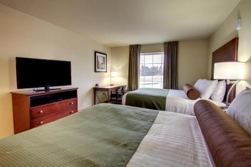 a hotel room with two beds and a flat screen tv at Stanton Inn and Suites in Stanton