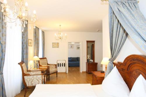 a bedroom with a bed and a living room at Hotel Rathausglöckel in Baden-Baden