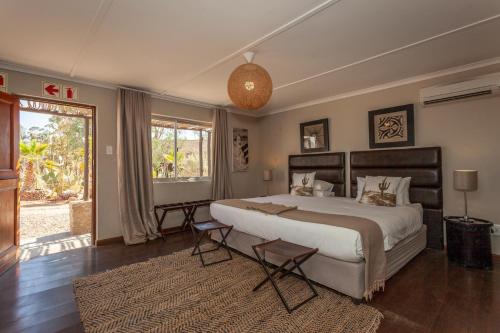 A bed or beds in a room at Inverdoorn Game Reserve Lodge