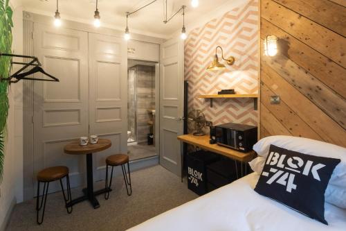a bedroom with a bed and a desk and a bathroom at Blok-74 in Brighton & Hove