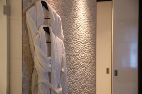 a bunch of towels hanging on a wall in a bathroom at Van der Valk Hotel Nuland - 's-Hertogenbosch in Nuland