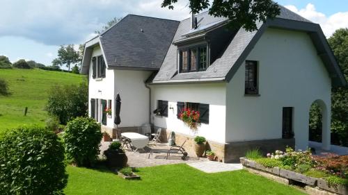 a white house with a green yard at L'Aubergine in Sprimont