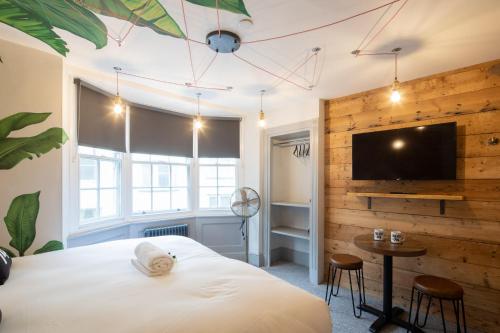 a bedroom with a large bed and a flat screen tv at Blok-74 in Brighton & Hove
