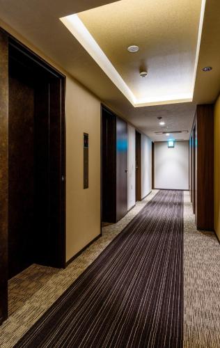 an empty hallway in a hotel room with a hallwayngth at QuintessaHotel TokyoHaneda Comic&Books in Tokyo