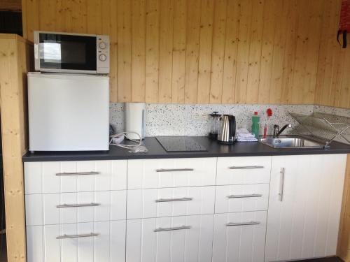 a kitchen with a white refrigerator and a sink at Cabin 3 at Lundar Farm in Varmaland