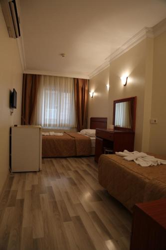 a hotel room with two beds and a mirror at EMOS HOTEL in Istanbul