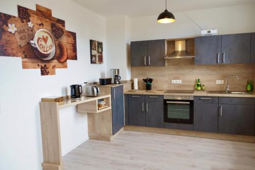 a kitchen with dark wood cabinets and a sink at Ferienwohnung Ostard 1 in Thale