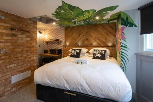a bedroom with a large white bed with a brick wall at Blok-74 in Brighton & Hove