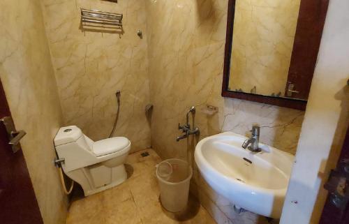 a bathroom with a sink and a toilet and a mirror at Royal Grand in Tambaram