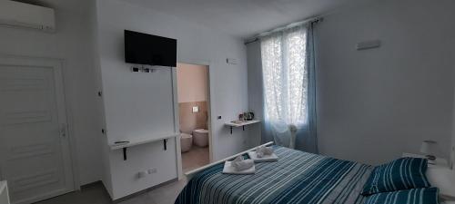 1 dormitorio con cama, TV y baño en Olimpo Affittacamere, en Manarola