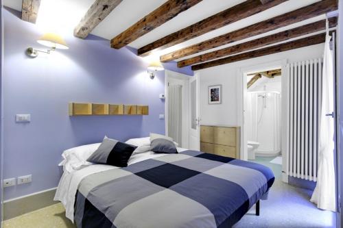 a blue and white bedroom with a large bed at Cozy Apartment up to 4 in Biennale Giardini by Bricola Apartments in Venice