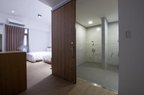 uma casa de banho com uma porta de vidro que leva a um quarto em LIANN Hotel em Taichung