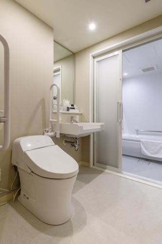 a bathroom with a toilet and a sink and a shower at QuintessaHotel TokyoHaneda Comic&Books in Tokyo