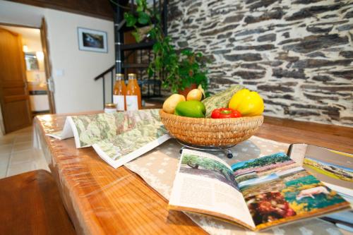 un tavolo con un libro e un cesto di frutta di Gites des Esperelles a Saint-Privat-de-Vallongue