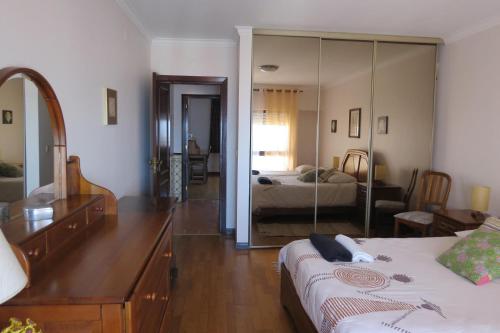 1 dormitorio con cama, tocador y espejo en Olá Ericeira Apartment, en Ericeira